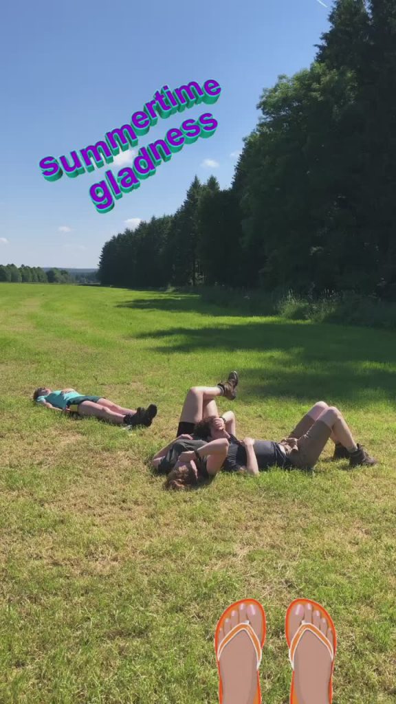 Drie wandelaars liggen vermoeid in het gras